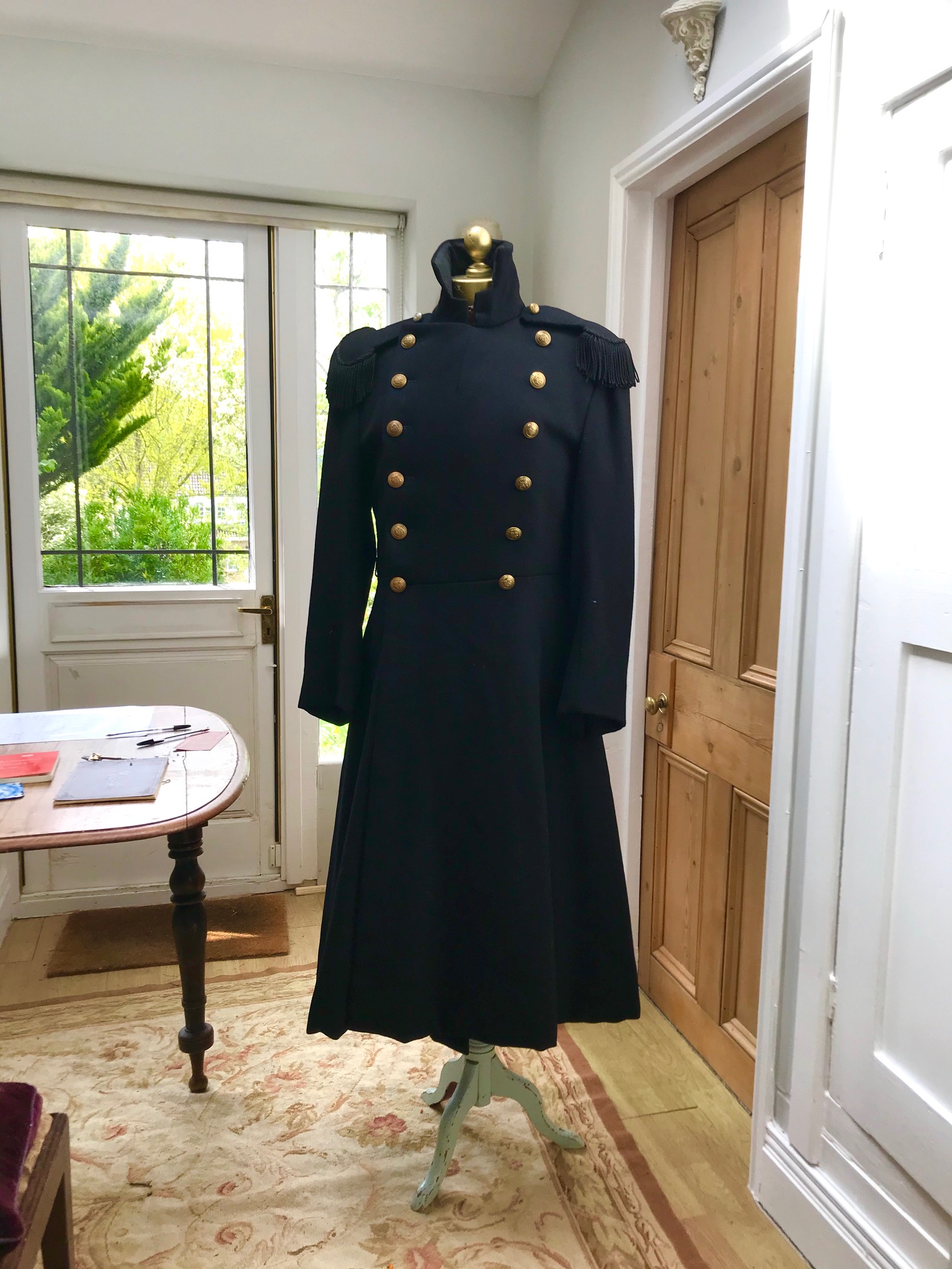 Two black military great coats with epaulettes and buttons. Ex Royal Opera House 'Tosca'